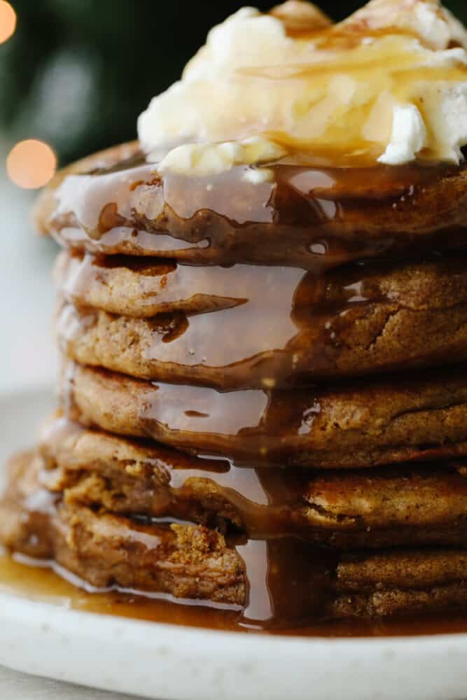 A stack of homemade pancakes drizzled with caramel syrup. 