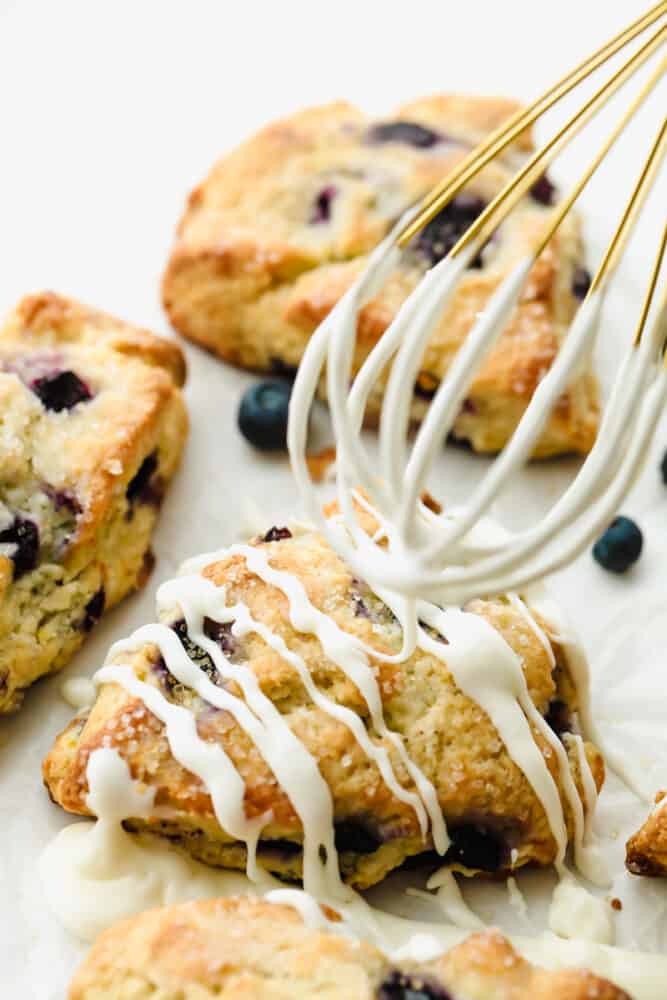 Drizzling icing on top of Blueberry Scones.