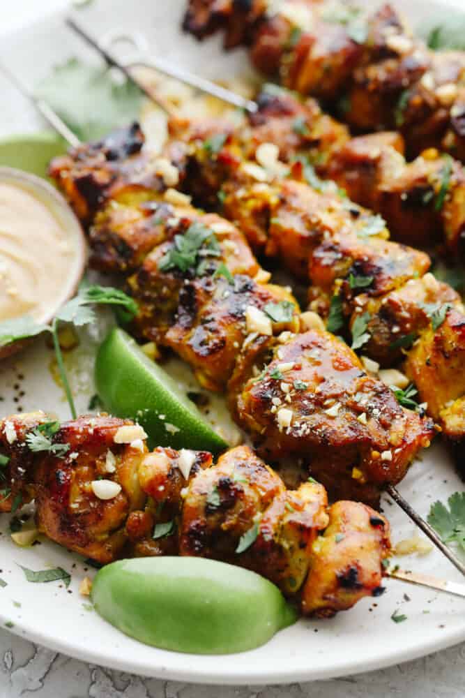Chicken on skewers grilled with chopped peanuts for garnish. 