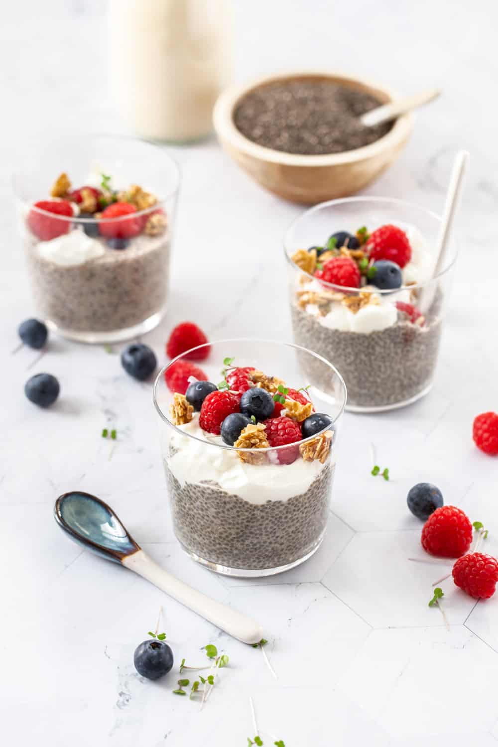 3 glasses with chia pudding, yoghurt and berries.