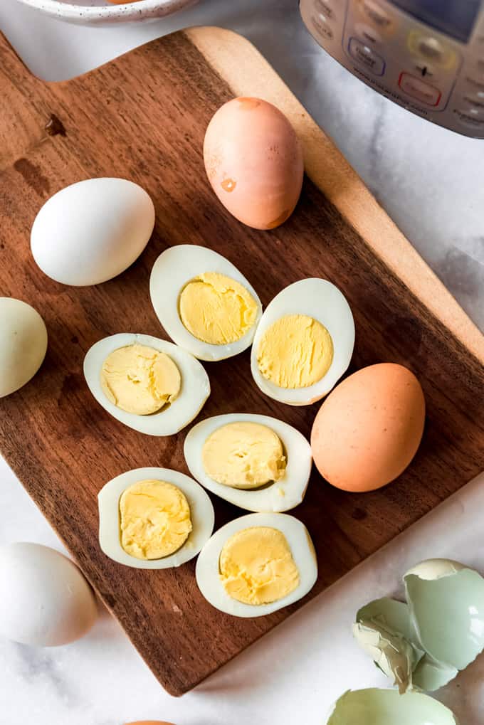 Sliced hard boiled eggs on a wooden cutting board.