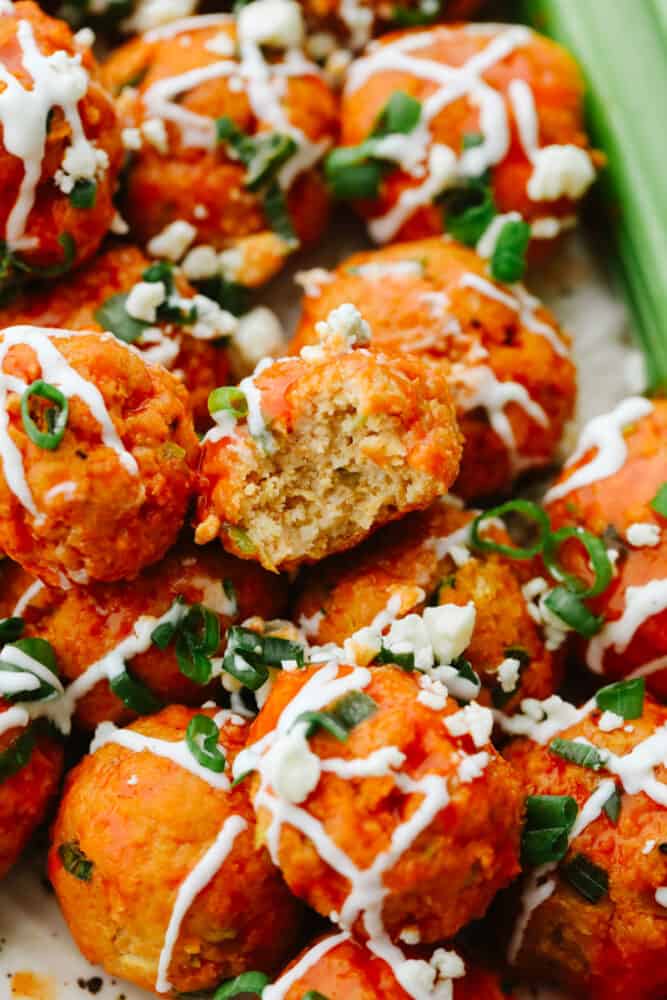 Buffalo chicken meatballs with a bite out of one of them. 