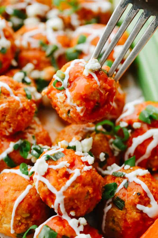 Up close photo of a chicken meatball on a fork.