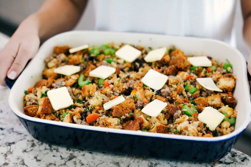 sausage herb stuffing in a baking dish with butter overtop