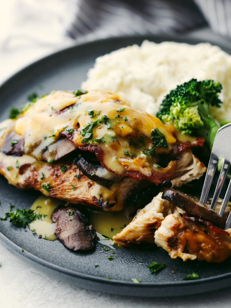 Alice Springs Chicken served on a gray plate with broccoli and mashed potatoes.