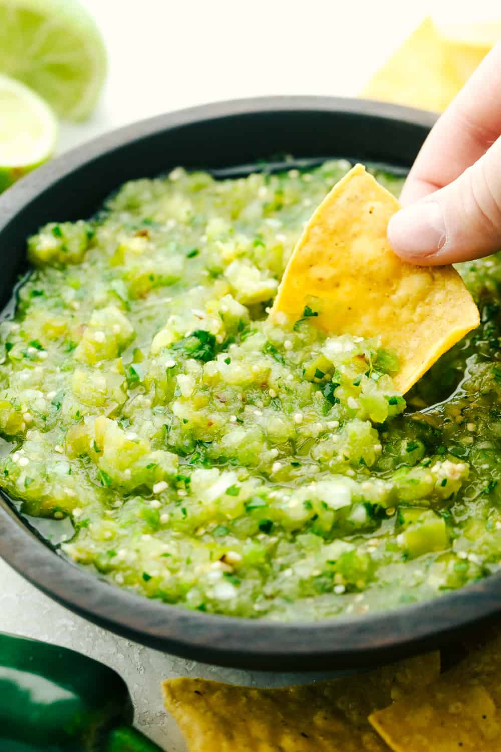 Dipping a chip in homemade salsa verde.