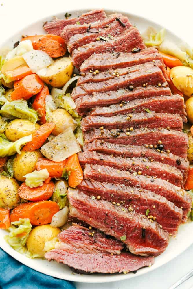 A platter of sliced corned beef with vegetables. 