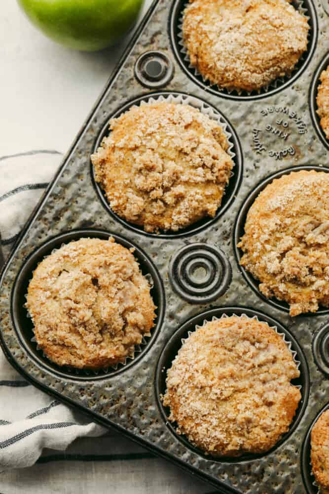 Apple streusel muffins in a muffin tin.