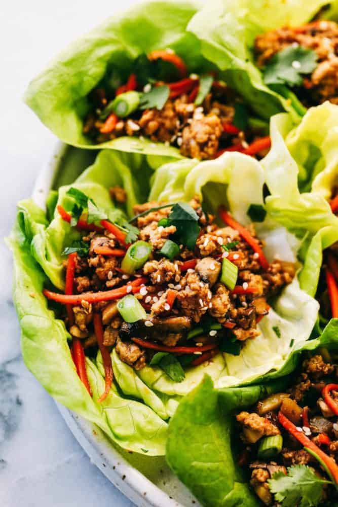 A zoomed in picture of a lettuce wrap garnished with sesame seeds. 