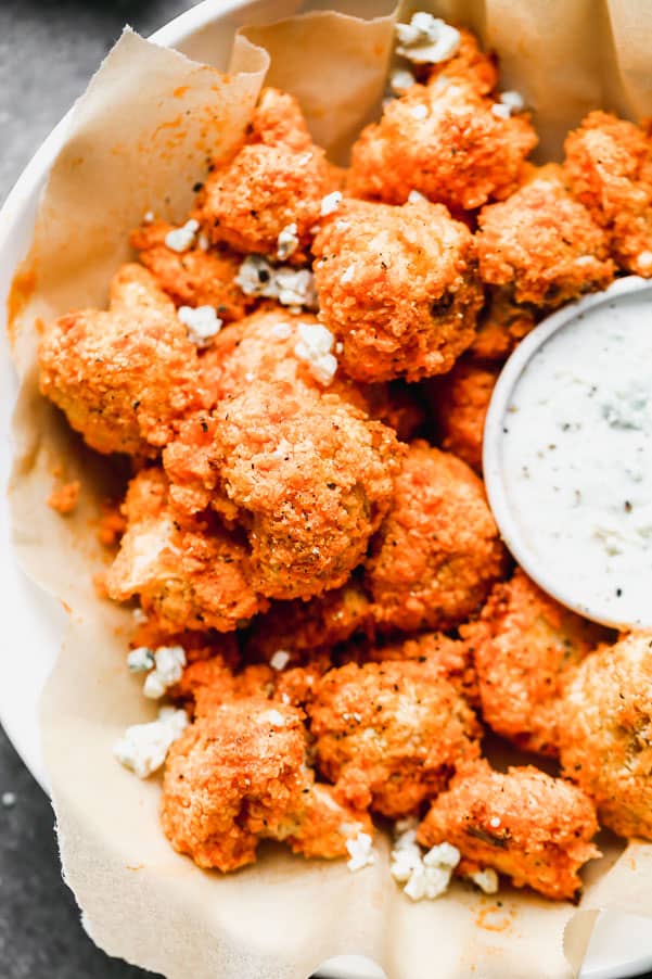 Buffalo cauliflower in a bowl with ranch dip on the side. 