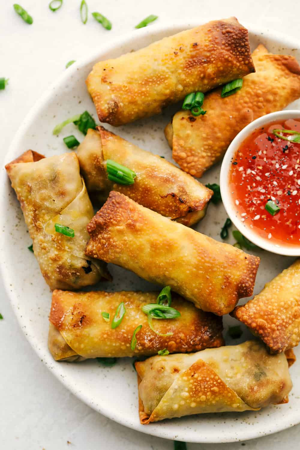 Air Fryer Egg Rolls on a platter with dipping sauce. 