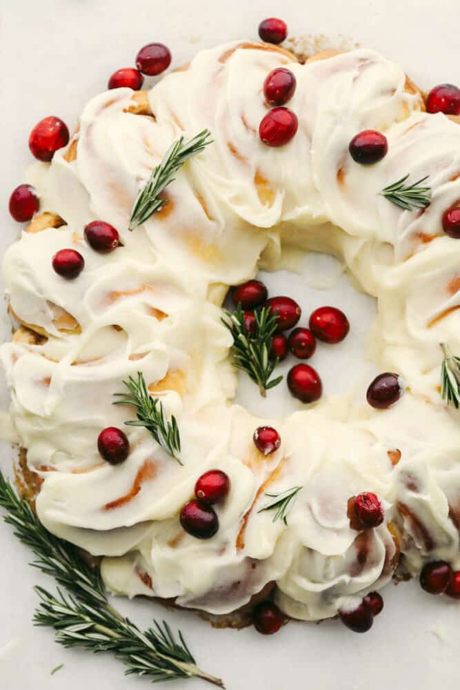 A cinnamon roll wreath with berries and garnish. 