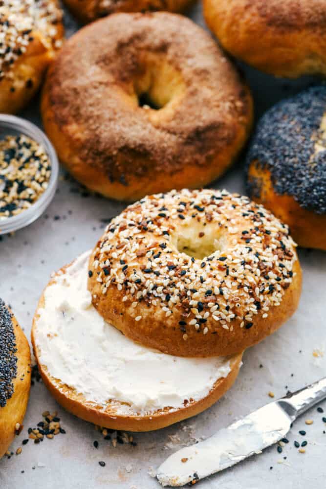 Homemade bagels with one sliced with cream cheese. 