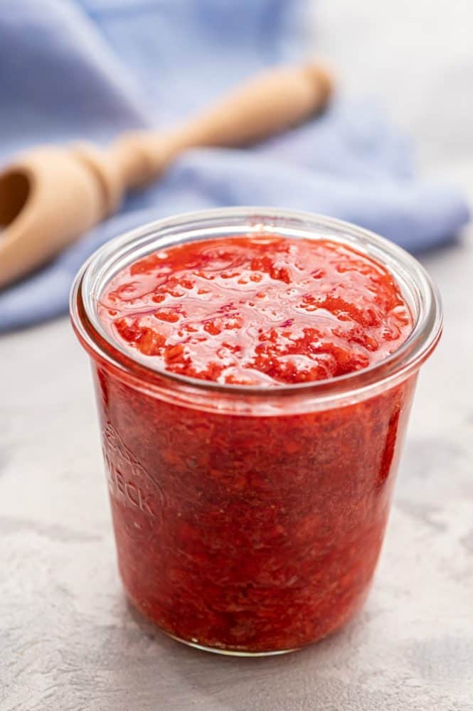 Strawberry freezer jam in a glass jar. 