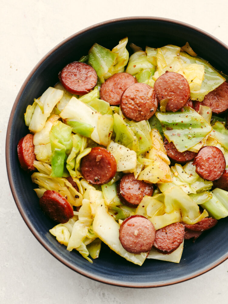 Sausage and cabbage in a blue bowl.